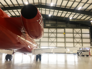 backside of red erj145 inside airplane hangar preparing for takeoff