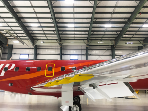 side view of red erj145 inside hangar